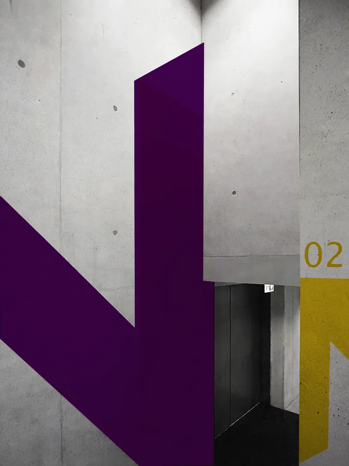 Leitsystem mit violettem Pfeil und der Nummer 02 an einer Betonwand.